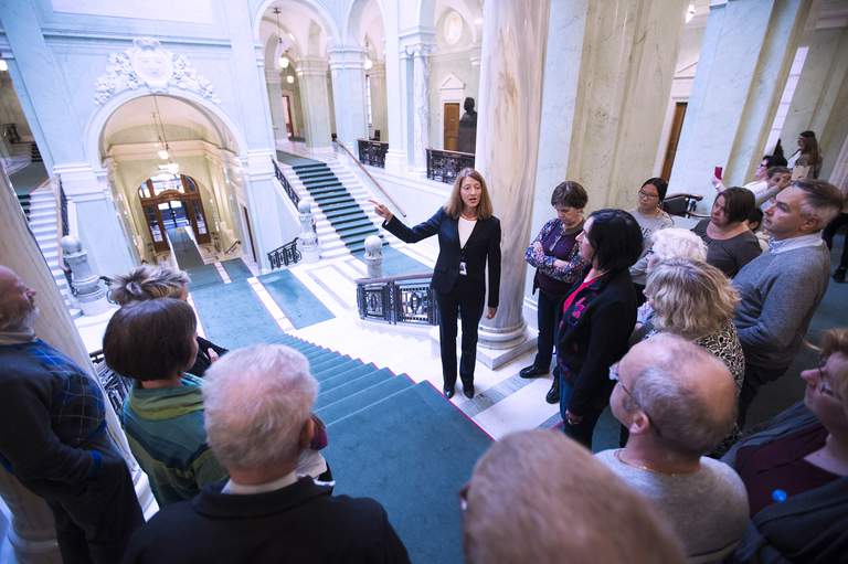 A group with a guide on a tour in the Riksdag.