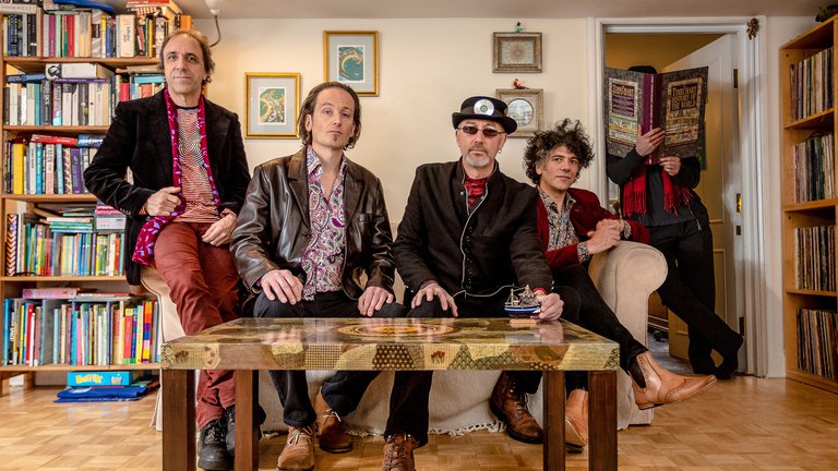 A photo of the band Gong sitting on a sofa.