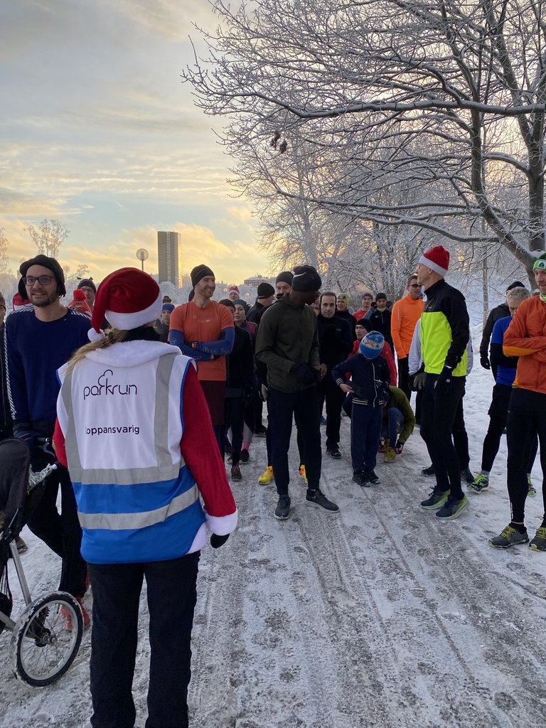 A group of people in training clothes in a park in winter.