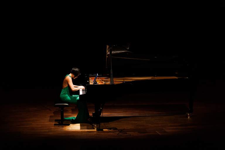 Music in Stockholm. Pianist Yuja Wang sitting in front of a piano, during a concert at The Stockholm Concert Hall.