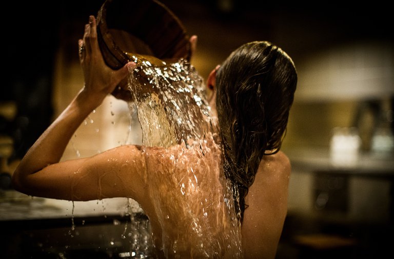 Wellness i Stockholm. En kvinna tar ett japanskt bad på Yasuragi, ett spa i Stockholm. Hennes rygg är vänd mot kameran och hon häller en hink med vatten över sig själv.