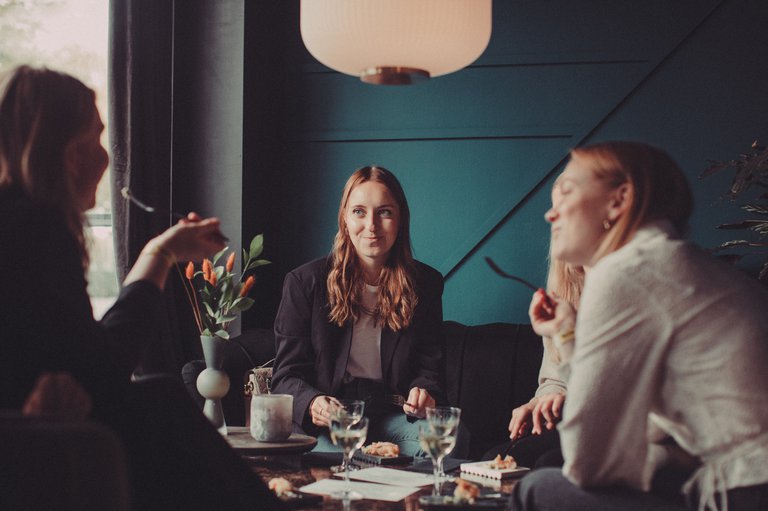 Three persons sitting and eating.