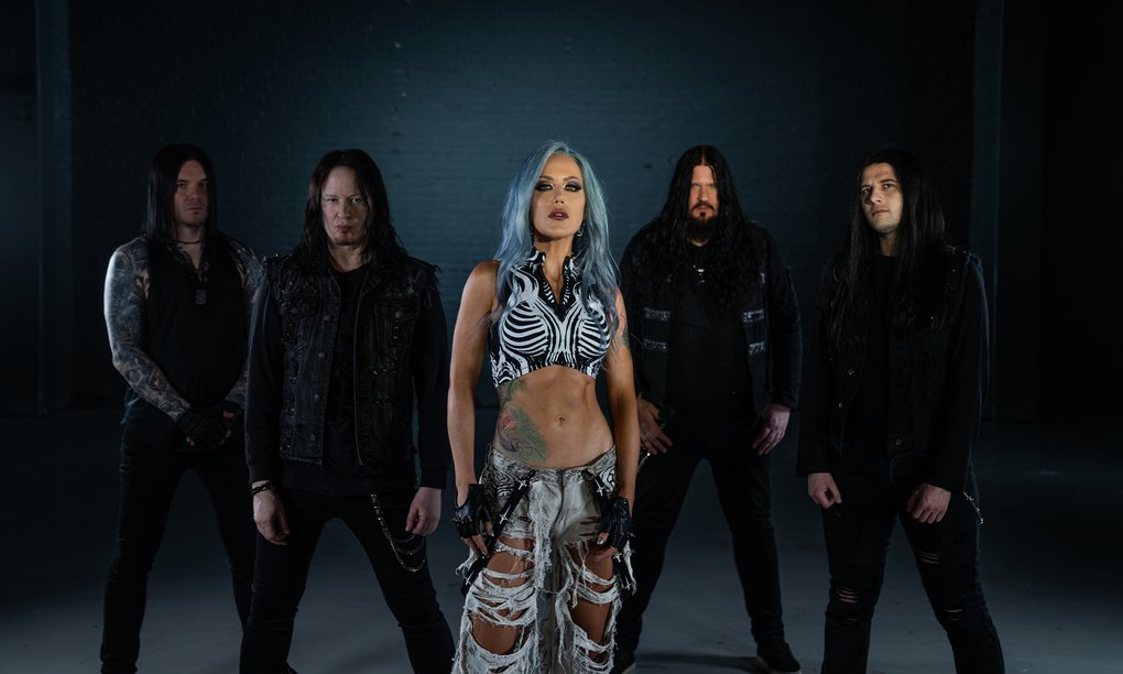 The five members of Arch Enemy standing in a dark room.