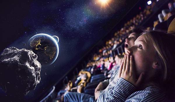 Children watching a film about the space.