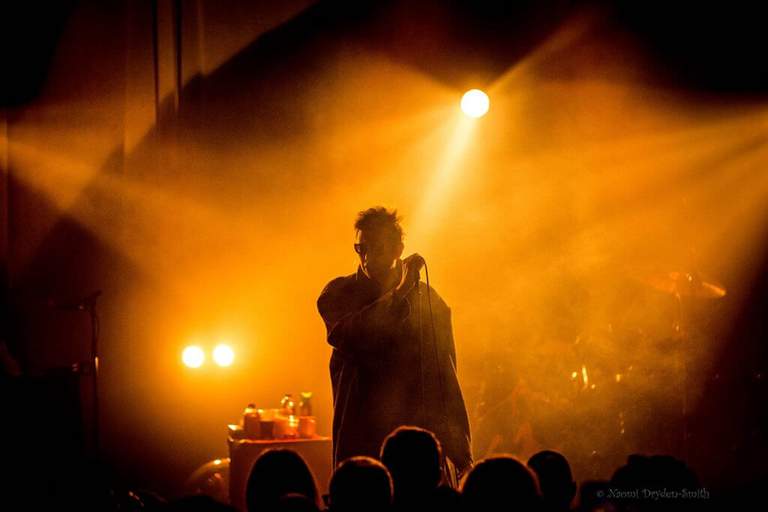 A musician on a stage in bright stage lights.