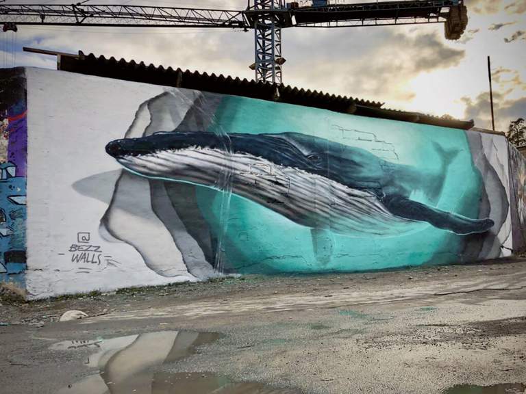 mural by artist Andreas “Bezz walls” Weidman, depicting a large whale on a brick wall