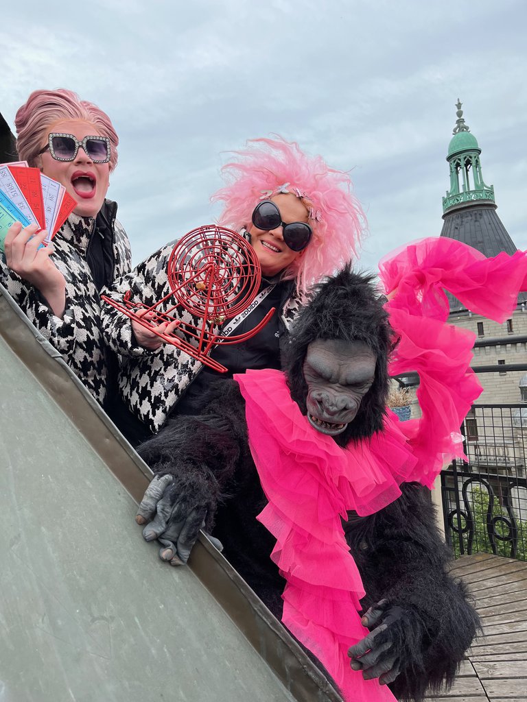 Two artists and a person dressed in a monkey costume.