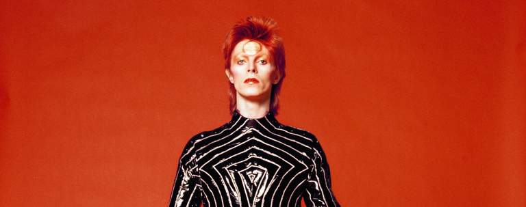 A photo of David Bowie with a red background.