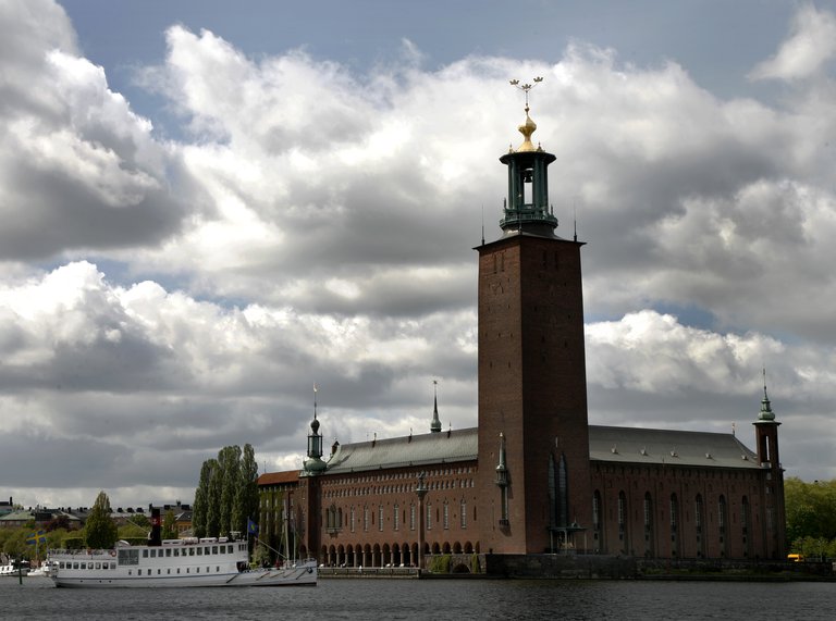 The Stockholm City hall and a boat on the water nearby.
