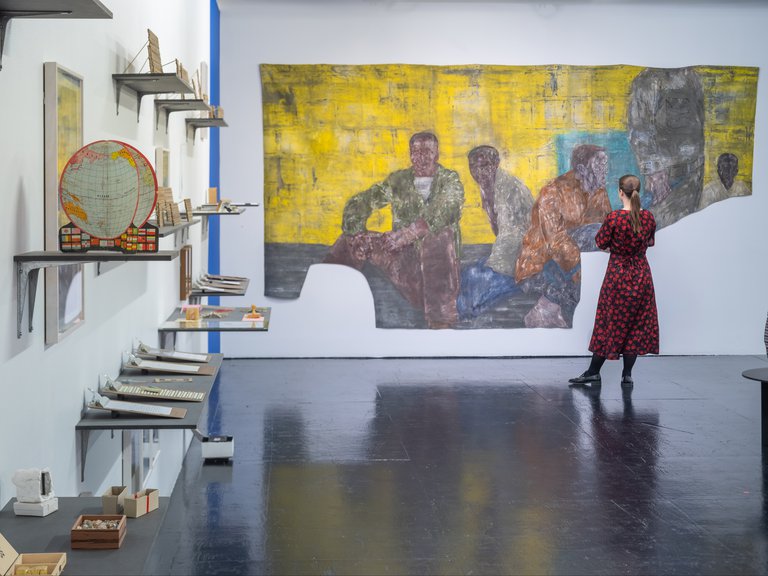 Museums in Stockholm. A woman is standing in front of a painting at Tensta Arthall. The paiting is "Fångar II" (1989) by Leon Golub.