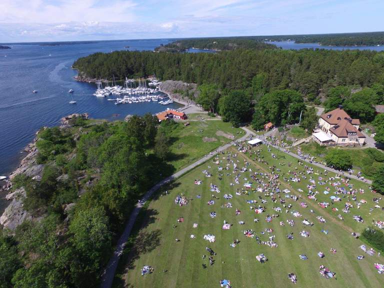 A view over people on a green island having a picnic.