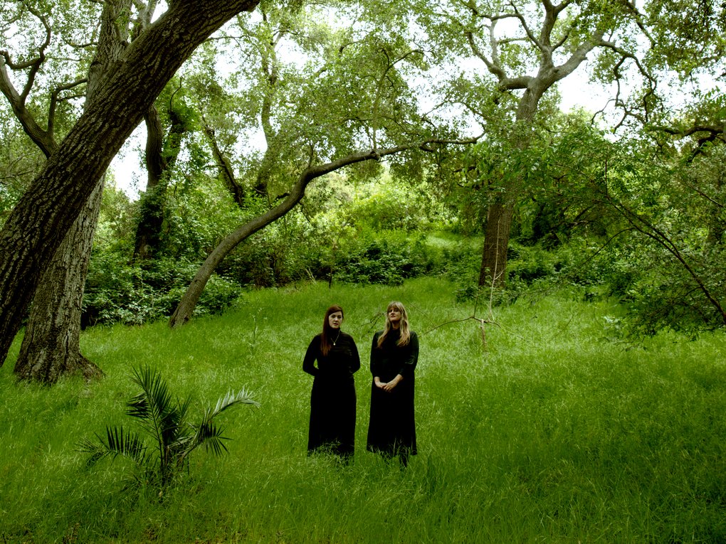 Julianna Barwick and Mary Lattimore standing in a meadow.