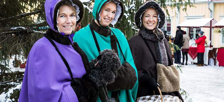 Three women in winter capes.