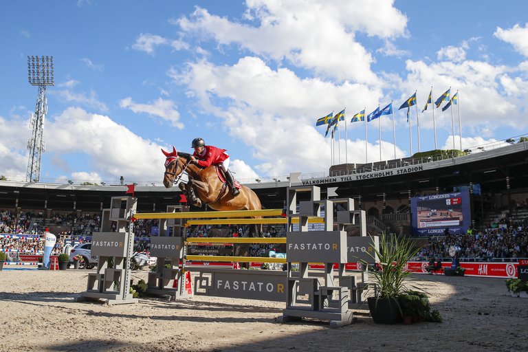A rider on a jumping horse.