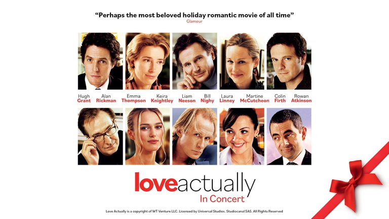 The poster shows a lineup of actors from the film ’Love Actually’ performing in concert form. The text above highlights it as one of the most beloved holiday romantic movies of all time.