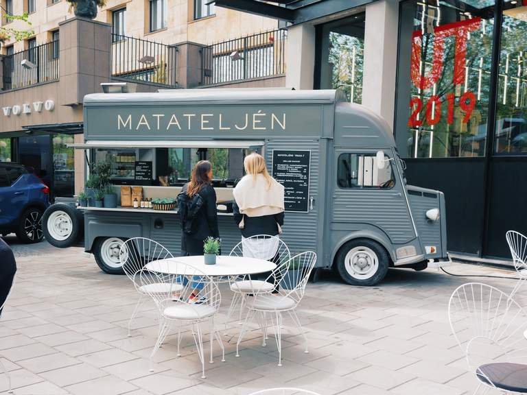 Food trucks in Stockholm. Two young women stand in front of a food truck in central Stockholm, looking at the menu and chosing what to order.