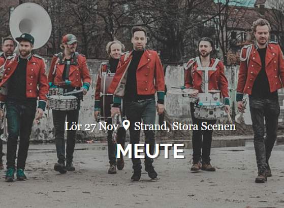 Meute posing in their red marching band jackets and instruments at the ready