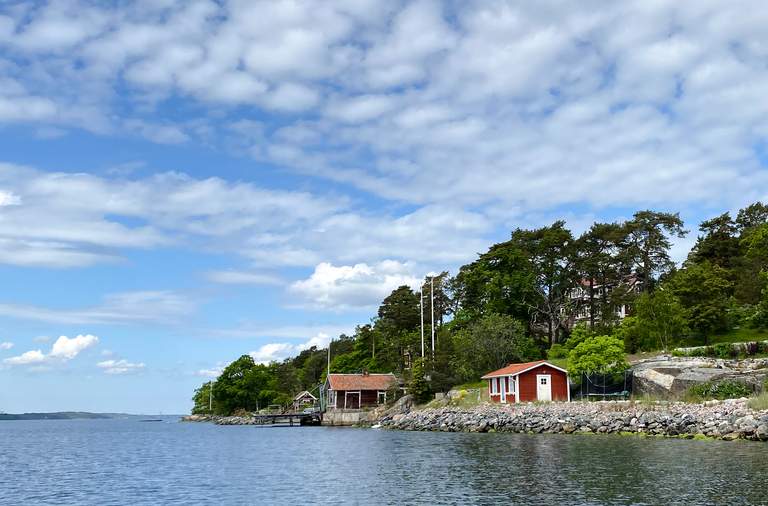 Stockholms skärgård, sommar. Två röda sommarstugor vid vattnet runt Möja.