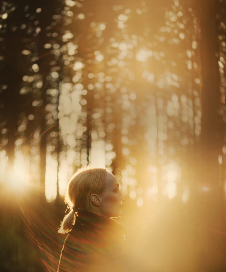 Moonica in profile against golden forest light