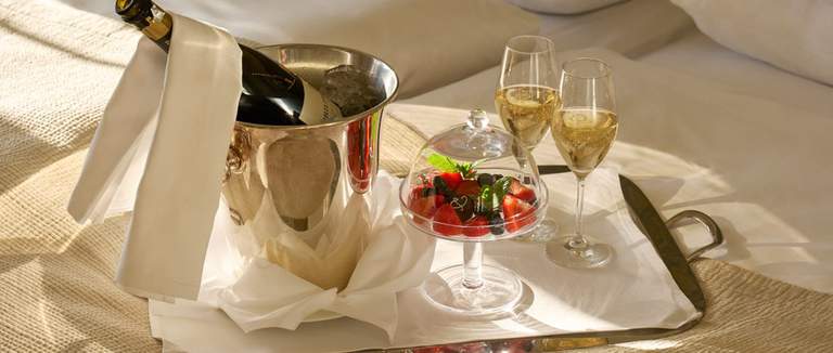 Champagne, champagne glasses, and fruit salad.
