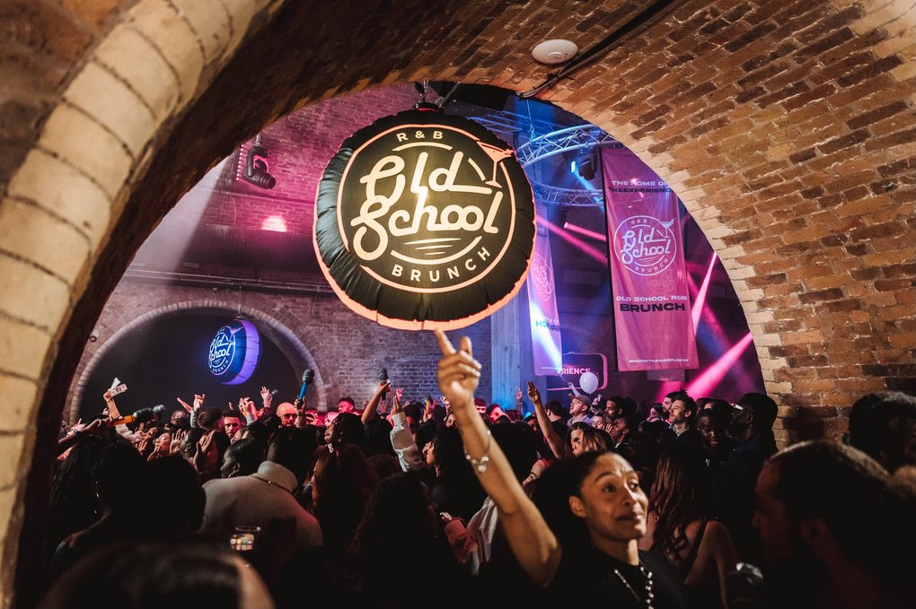 A dancing crowd at a club in a brick building.