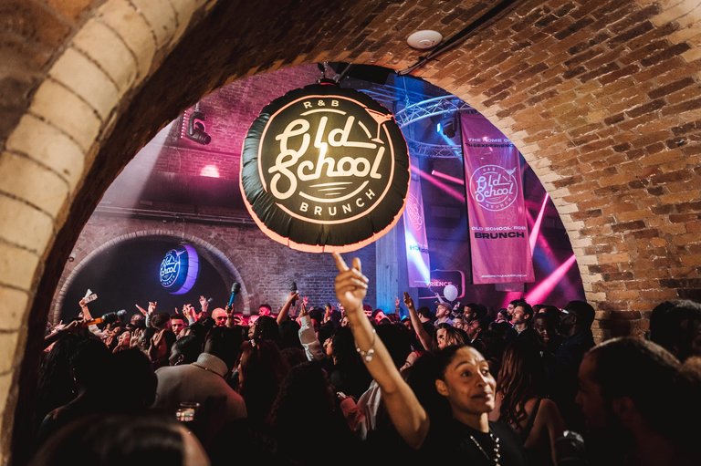 A dancing crowd at a club in a brick building.