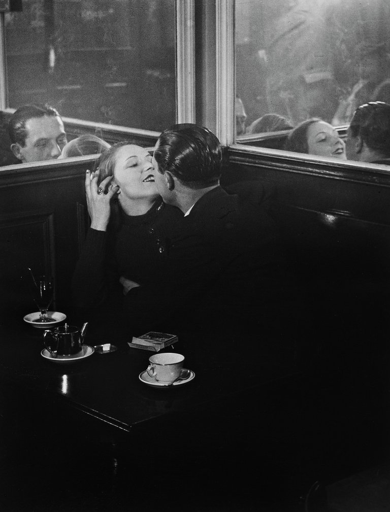 A photograph of a loving couple at a litte french café