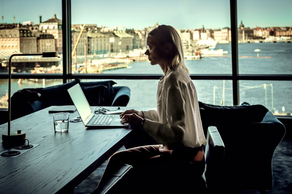 Woman working in Stockholm with panoramic view over the Old Town and the city