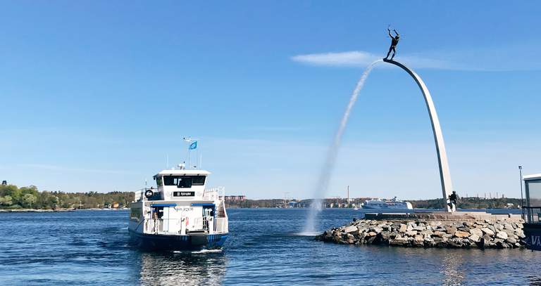 Summer in the Stockholm archipelago. A commuter ferry arrives in Nacka strand. Pictured is also Carl Milles statue, greeting passengers as they arrive.