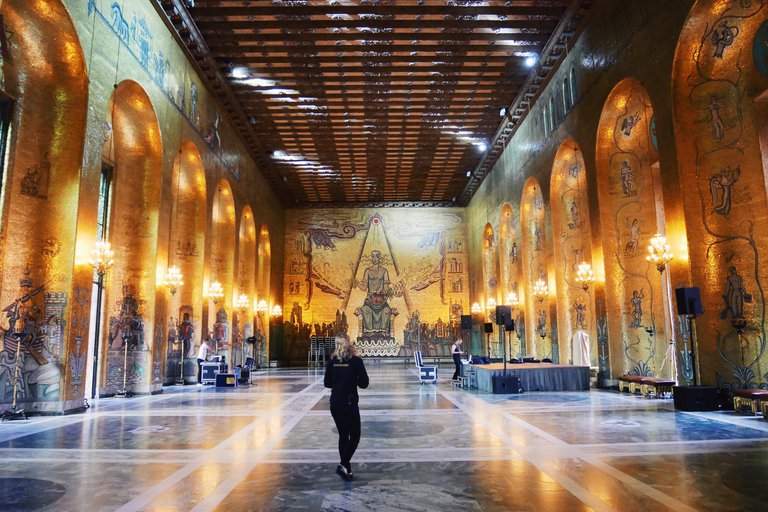 Attractions in Stockholm. Gyllene salen ("The Golden Hall") in the Stockholm City Hall. A gilded room with a high ceiling. The back wall is covered by a large mosaic of Saint Erik, the patron saint of Stockholm.