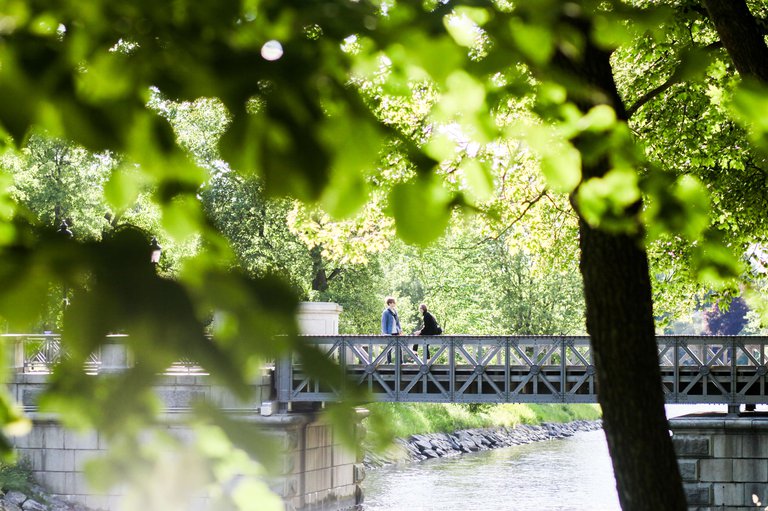 Two people walk over a bridge in Djurgården, a large parkland area in Stockholm