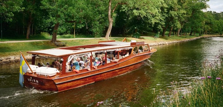 a wooden boat with people on a sightseeing tour