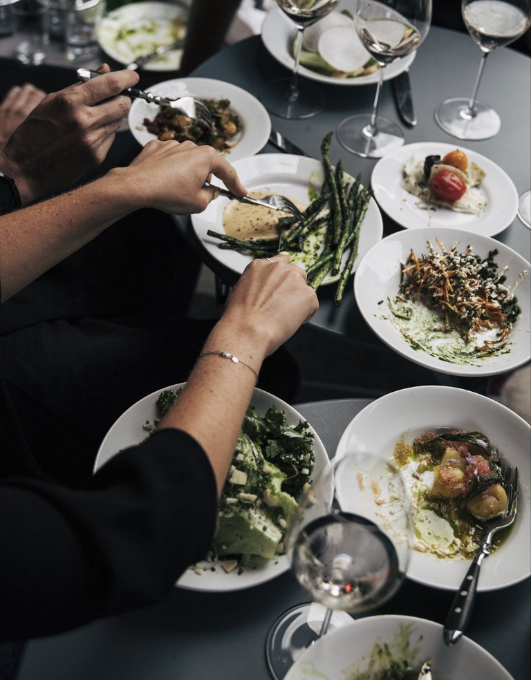 Food in Stockholm. A pair of hands is cutting food on a plate.